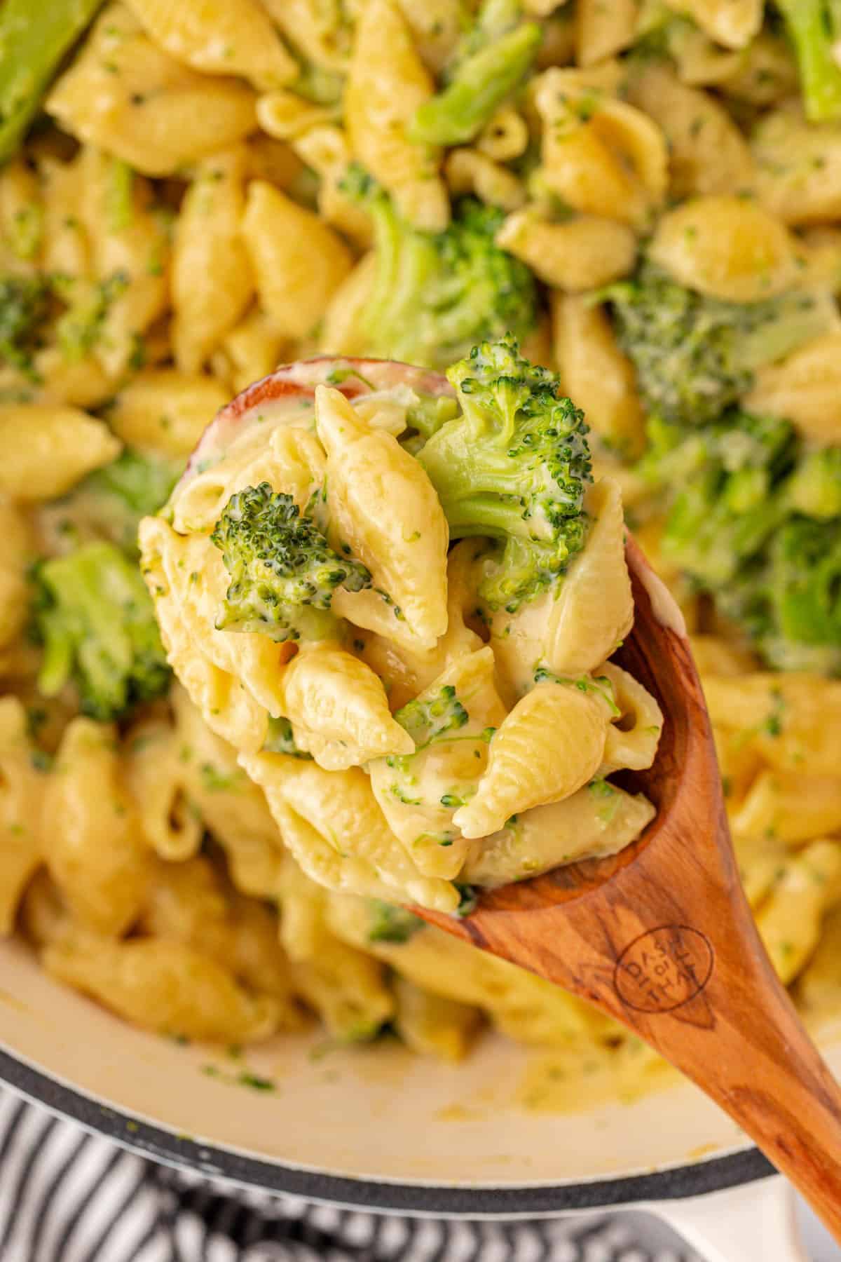 scooping broccoli mac and cheese from the pan
