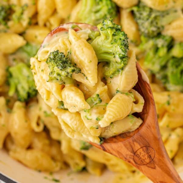 scooping broccoli mac and cheese from the pan