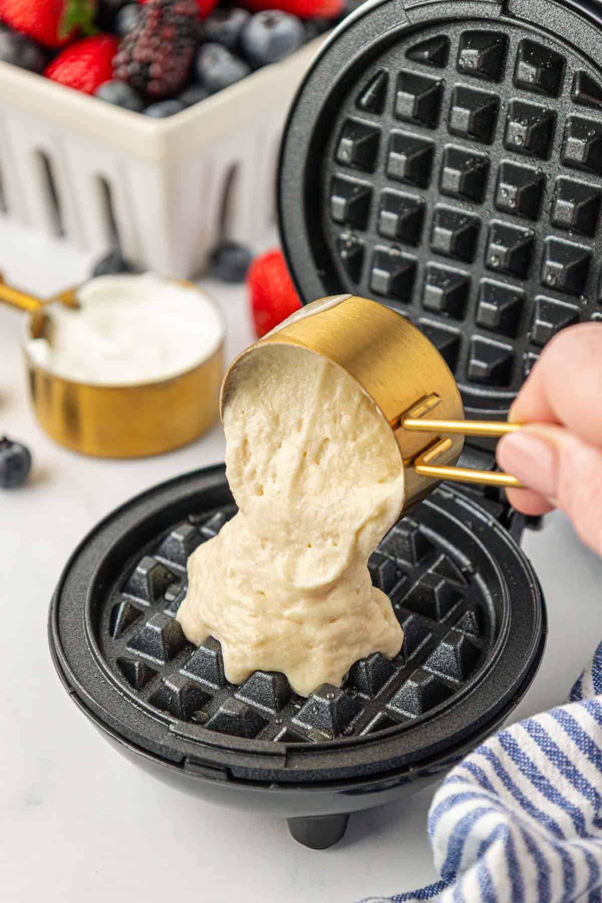 pouring batter into a mini waffle maker