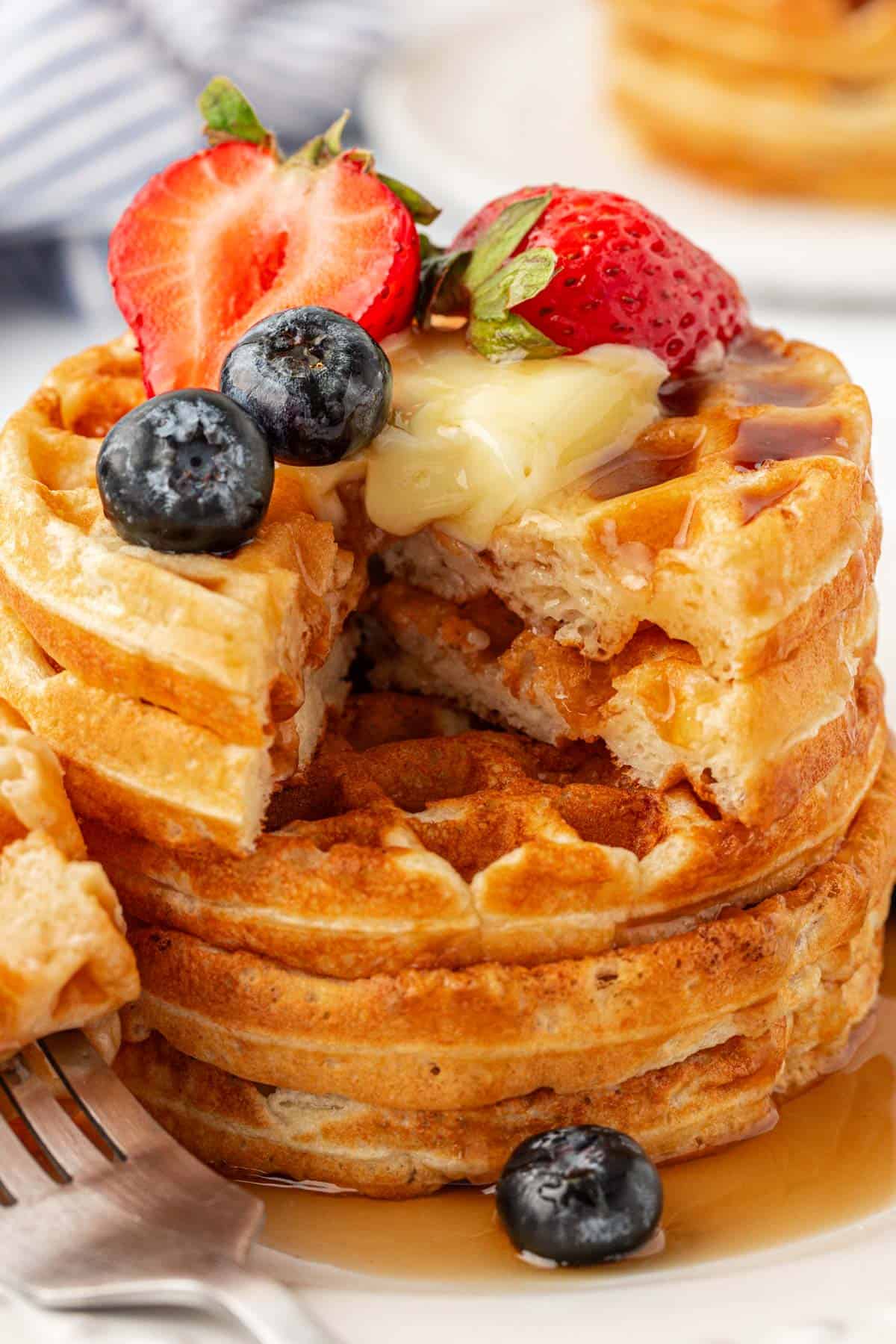 Greek yogurt waffles topped with fruit, syrup, and butter