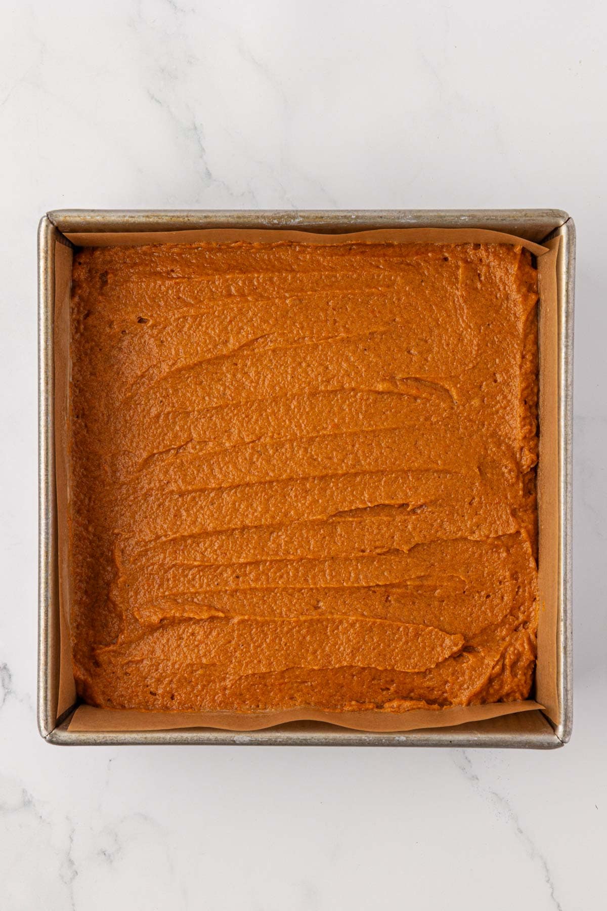 pumpkin bread batter spread out in a pan