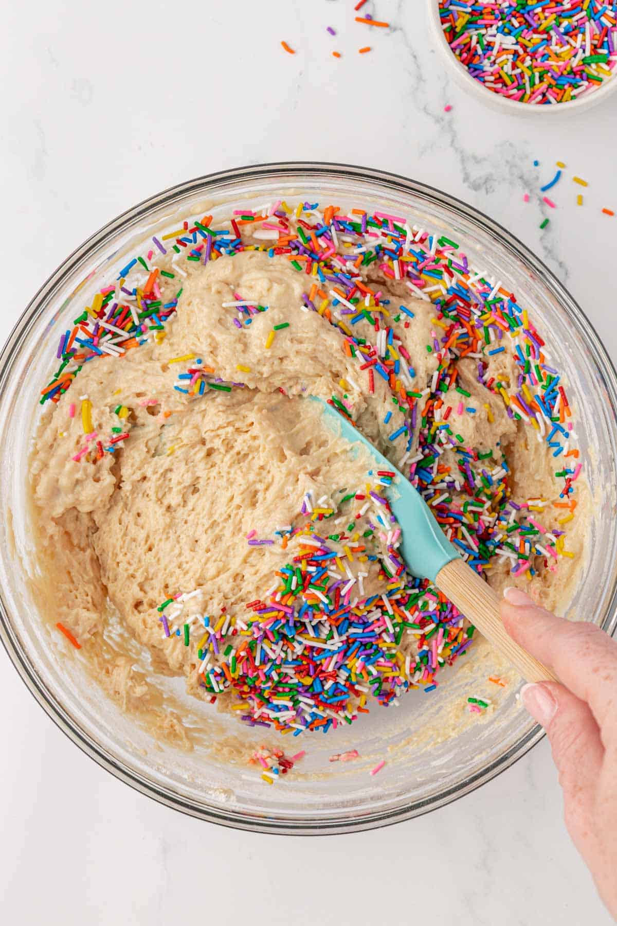 folding sprinkles into the muffin batter