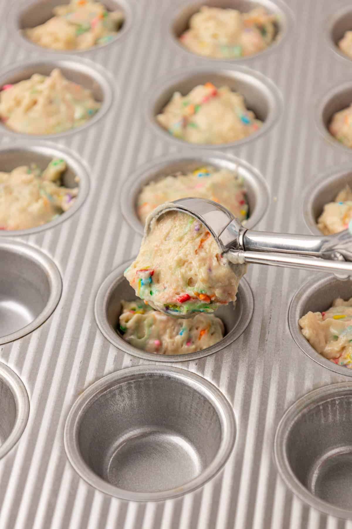 scooping the batter into a mini muffin tin
