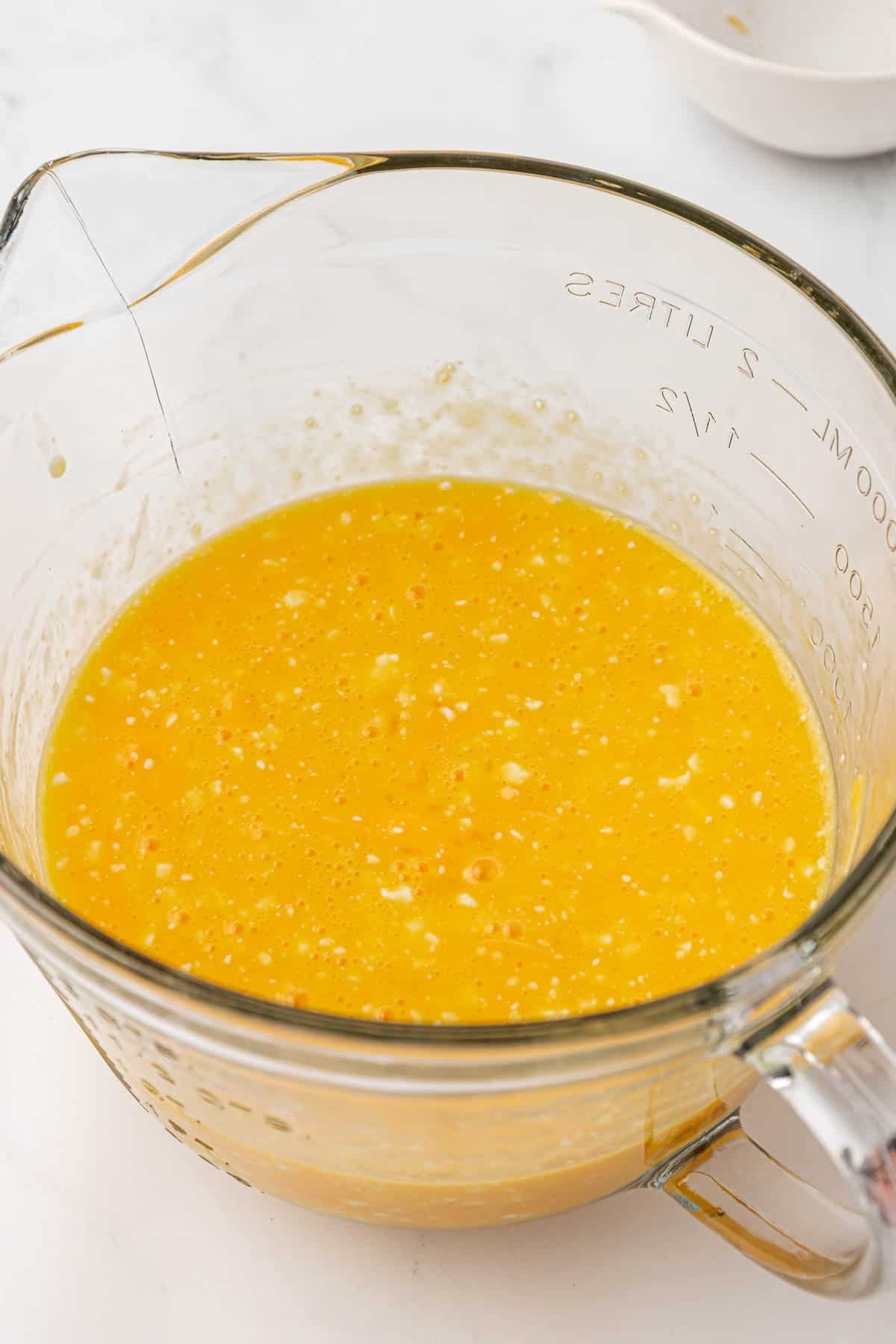 eggs whisked together with cottage cheese in a measuring cup