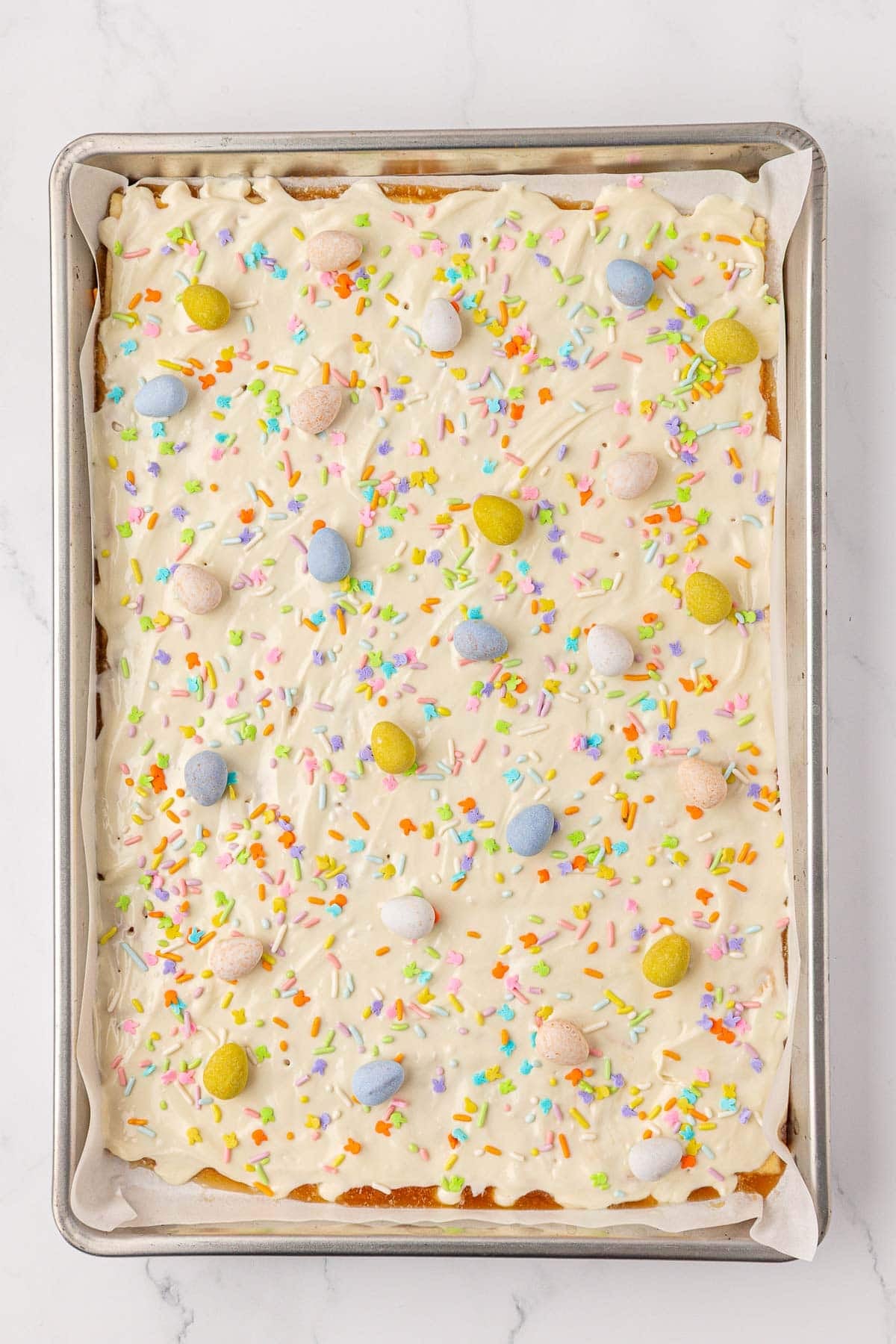 topping the melted white chocolate with Easter sprinkles and cadbury mini eggs