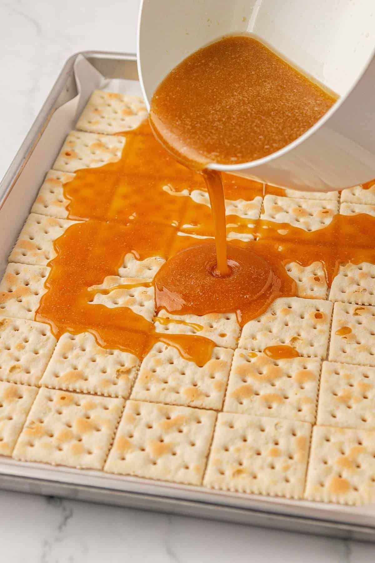 pouring toffee over the saltine crackers