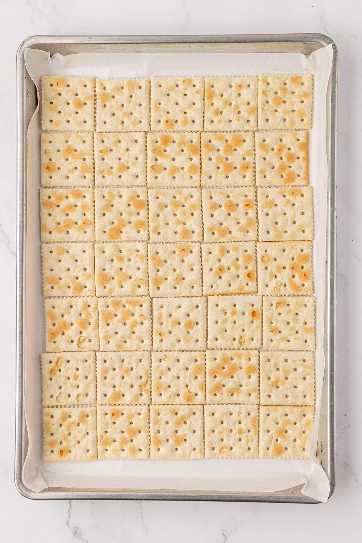 a baking sheet lined with saltine crackers