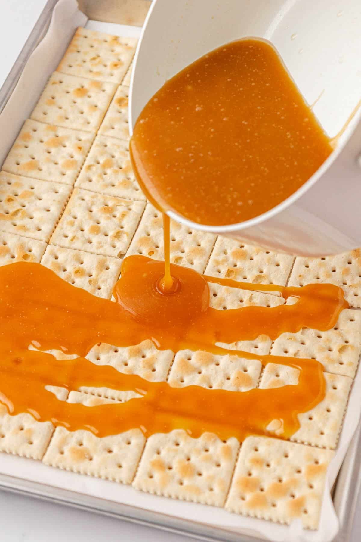 pouring toffee over saltine crackers