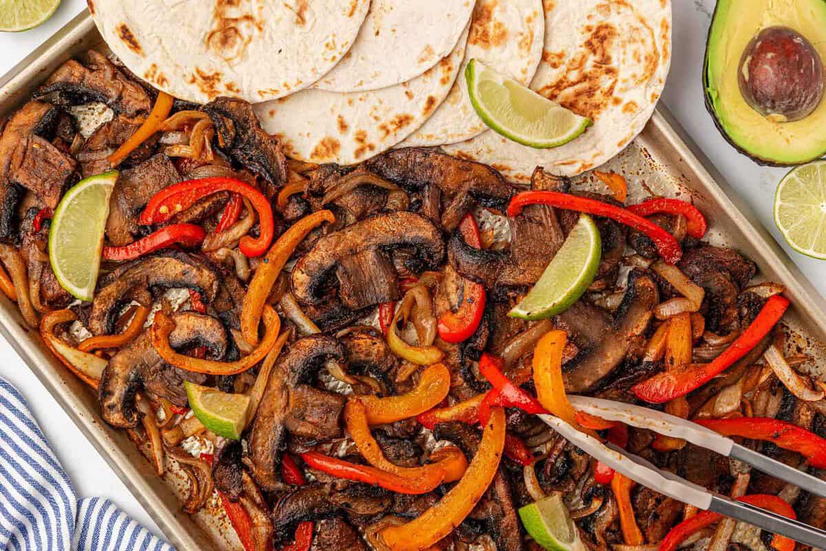 portobello mushroom fajita veggies on a sheet pan with flour tortillas