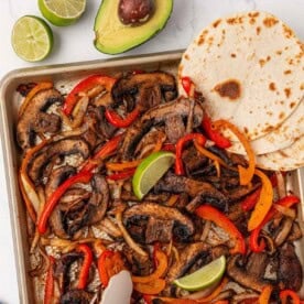 portobello mushroom fajita veggies on a sheet pan with flour tortillas