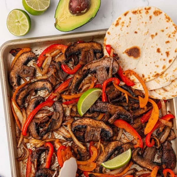portobello mushroom fajita veggies on a sheet pan with flour tortillas