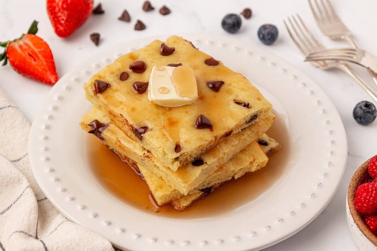 sheet pan pancakes topped with butter and maple syrup