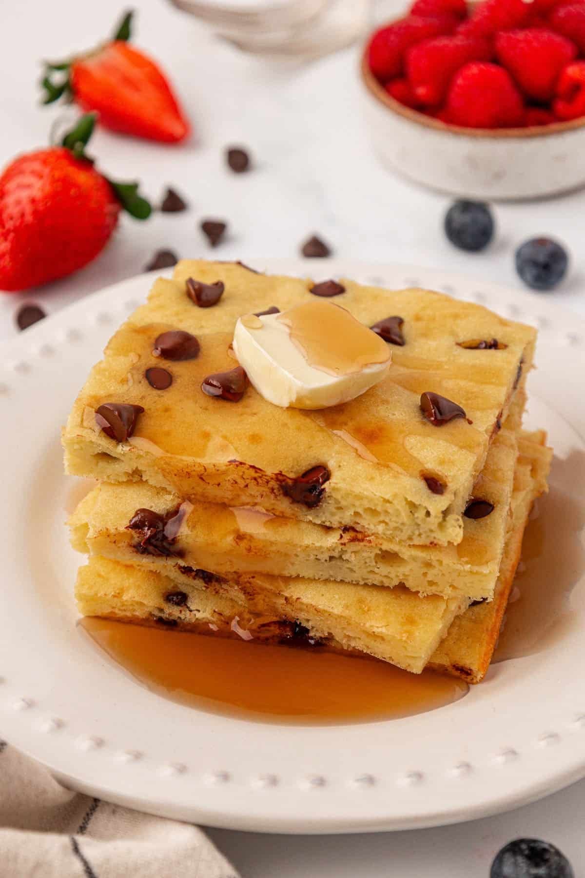 sheet pan pancakes topped with butter and maple syrup