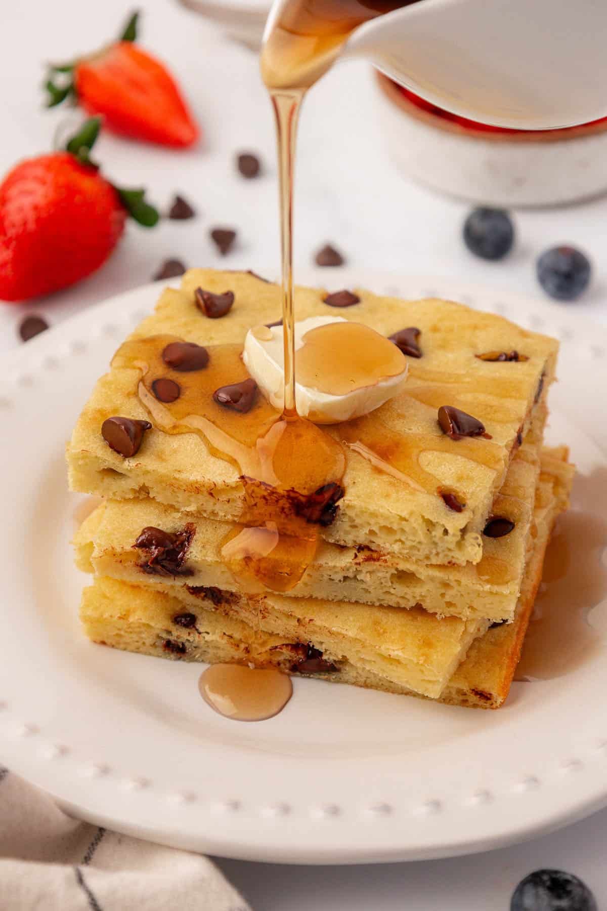 sheet pan pancakes topped with butter and maple syrup
