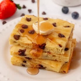 sheet pan pancakes topped with butter and maple syrup