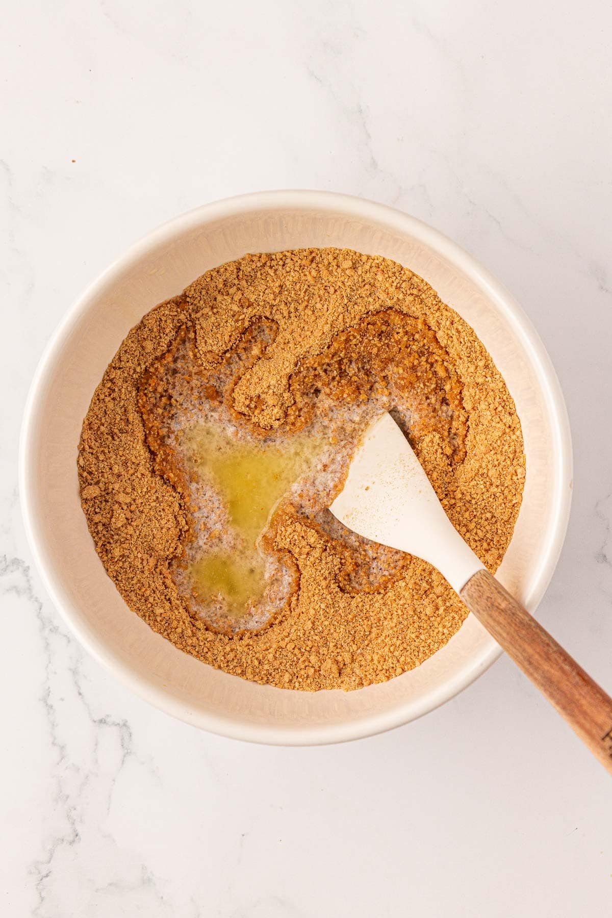 adding the butter to the graham cracker crust