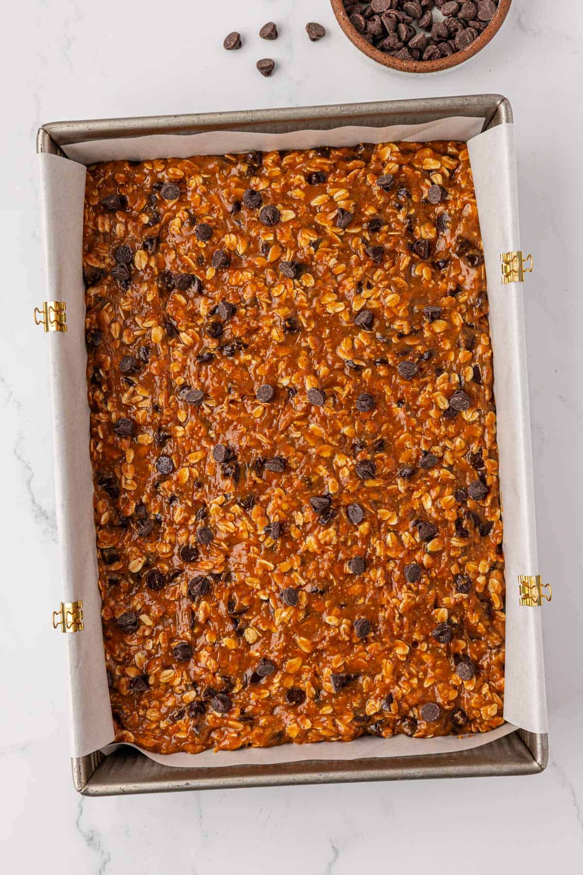 cookie bar batter spread into a baking dish