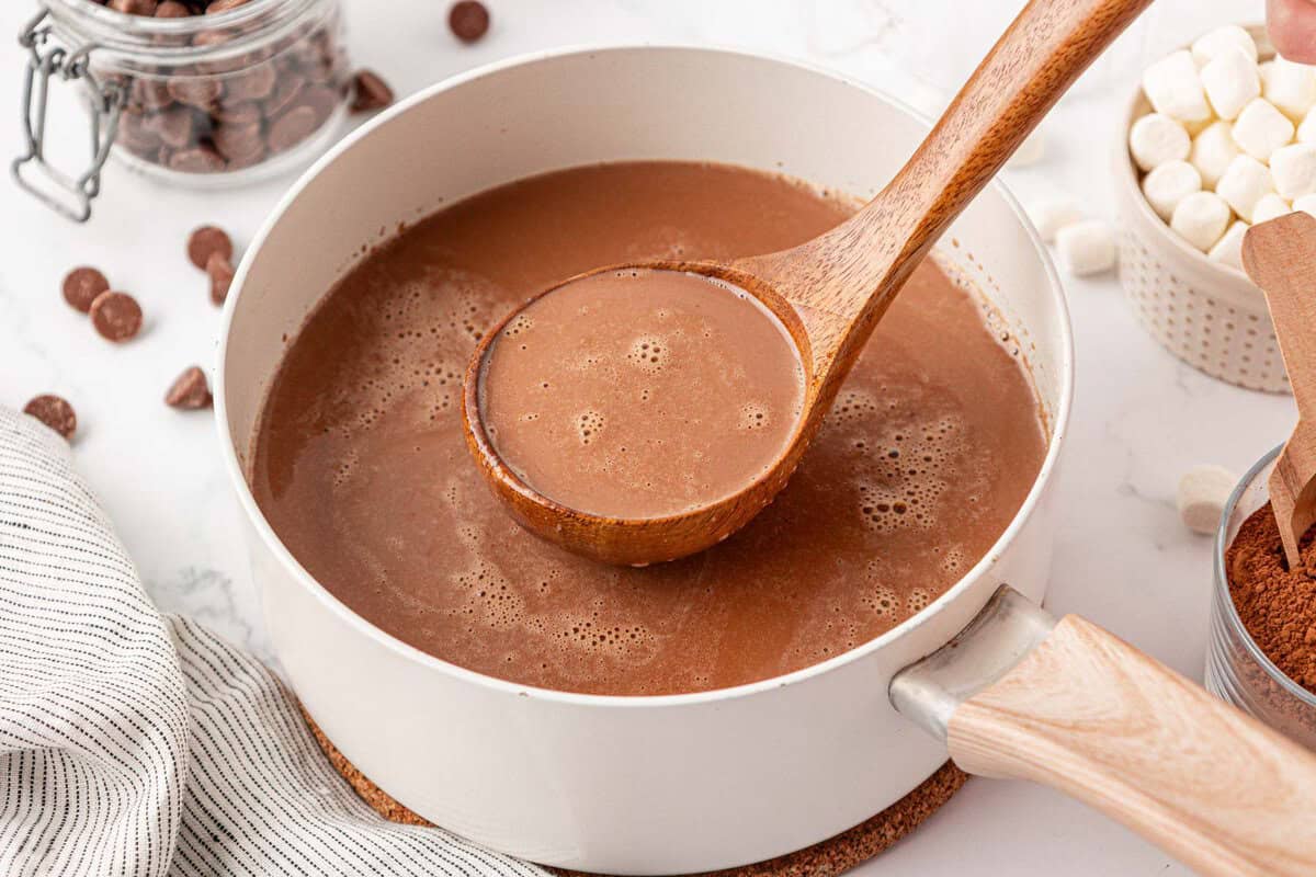 a ladle with hot chocolate over a pot