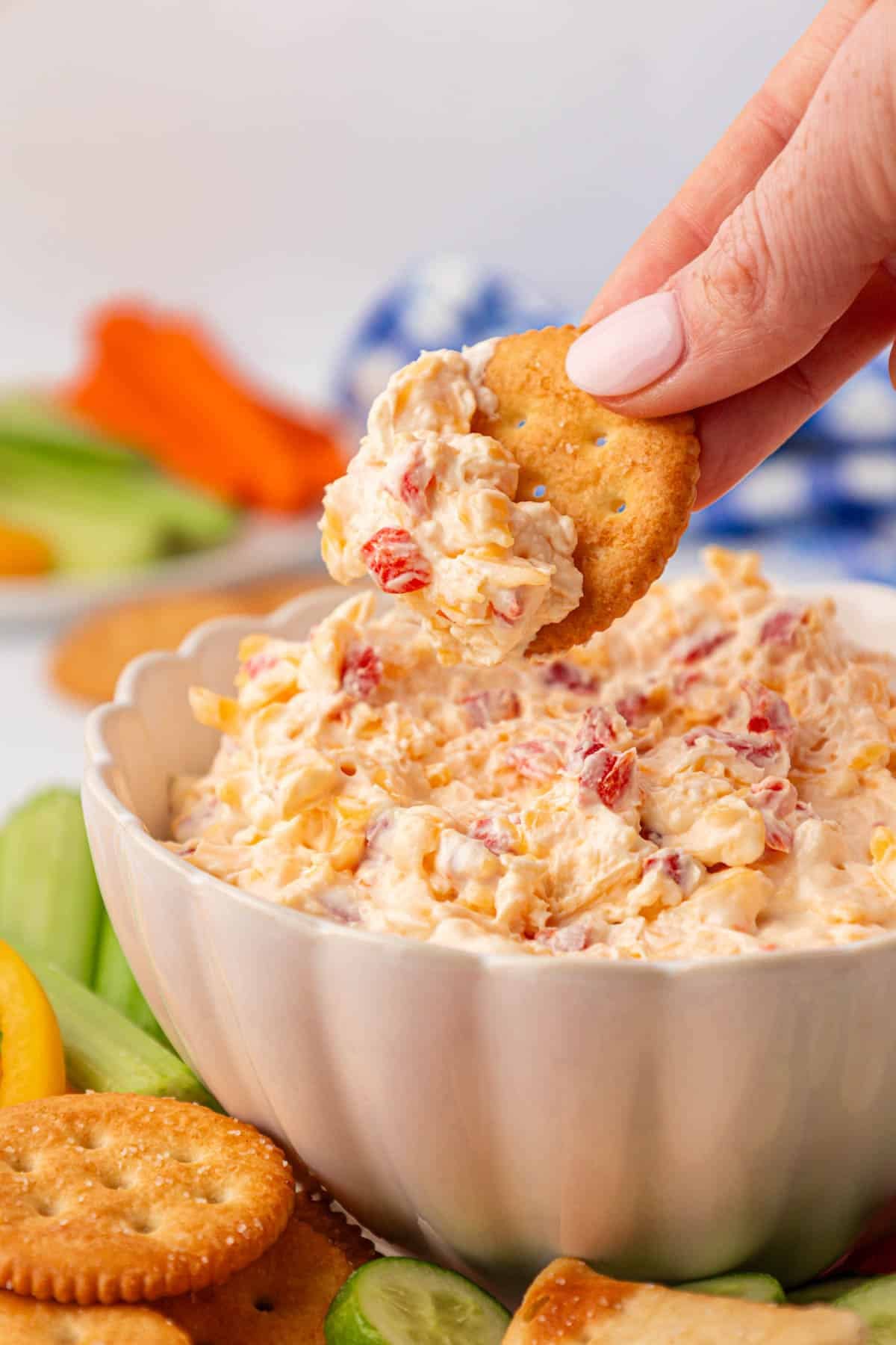 dipping a cracker into pimento cheese dip