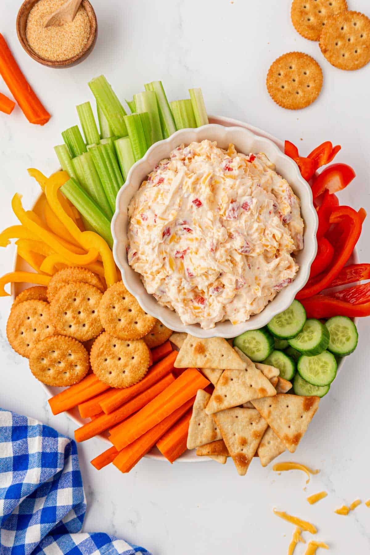 pimento cheese dip on a platter with crackers and vegetables