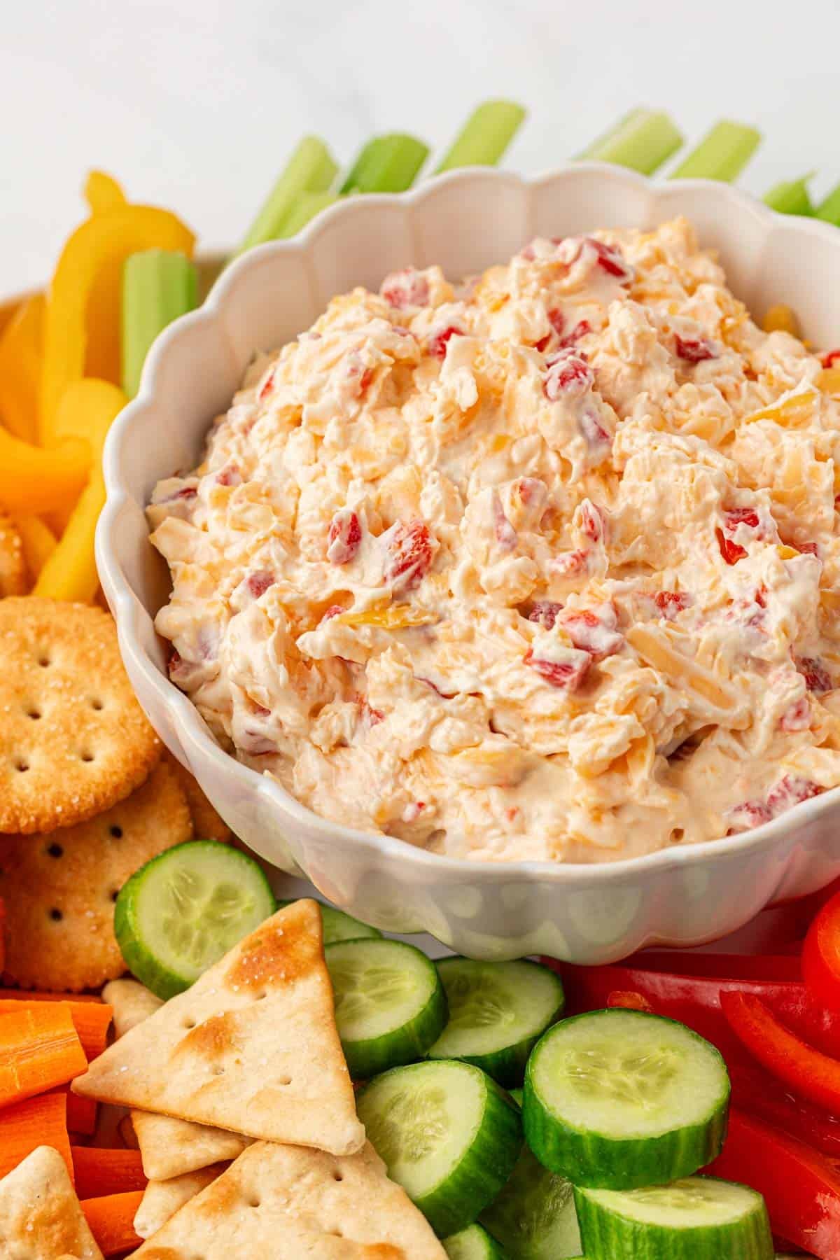 pimento cheese dip on a platter with crackers and vegetables