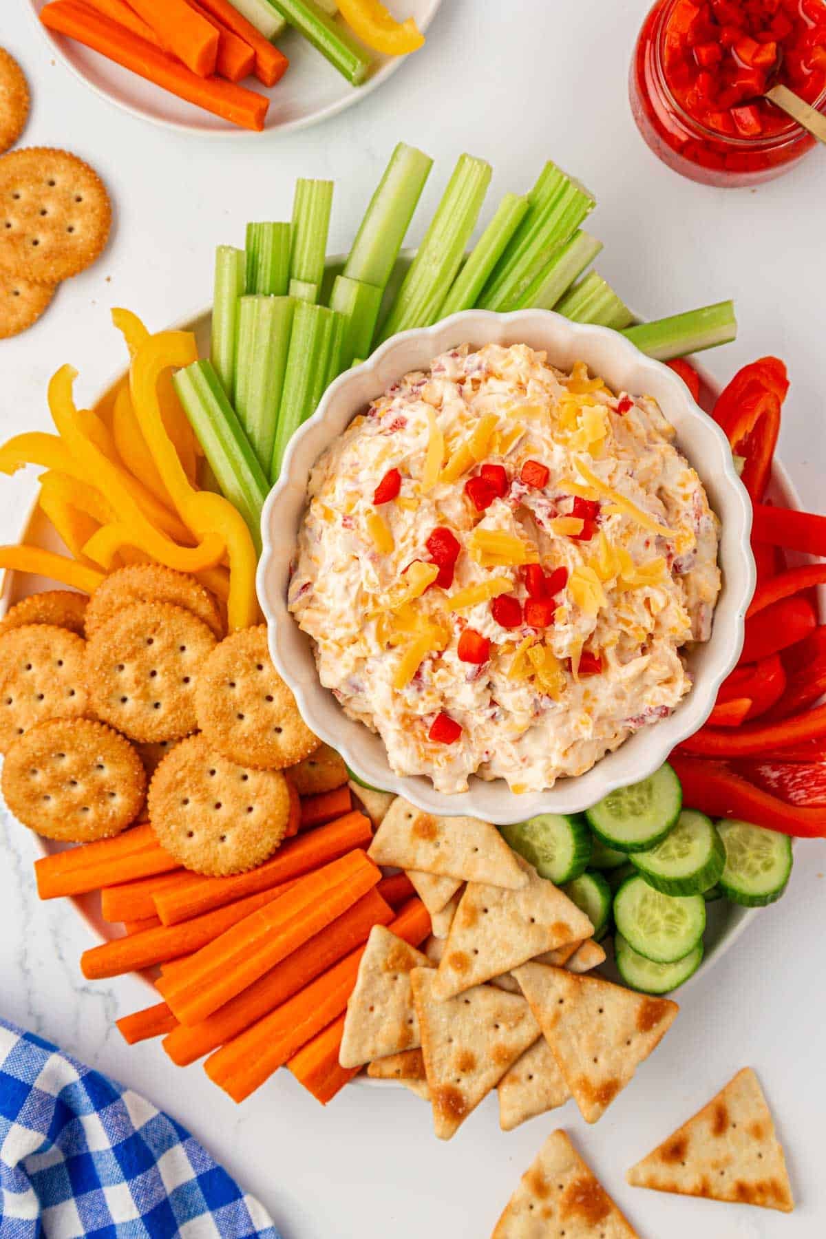 pimento cheese dip on a platter with crackers and vegetables