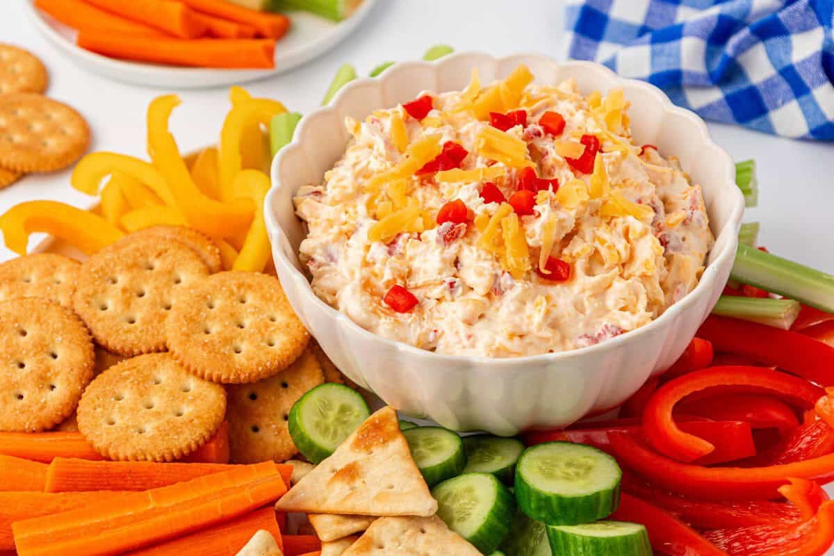 pimento cheese dip on a platter with crackers and vegetables