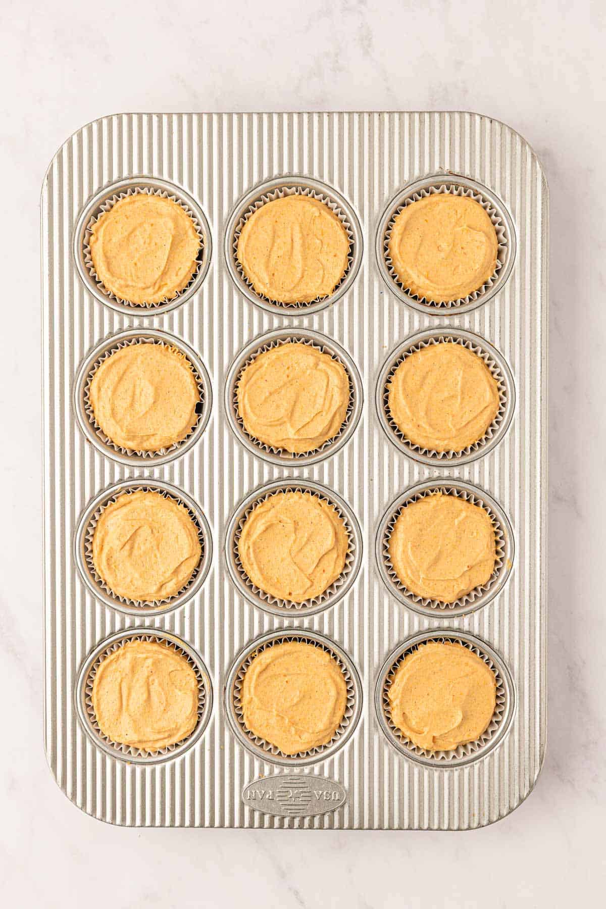 mini pumpkin cheesecakes in a muffin tin
