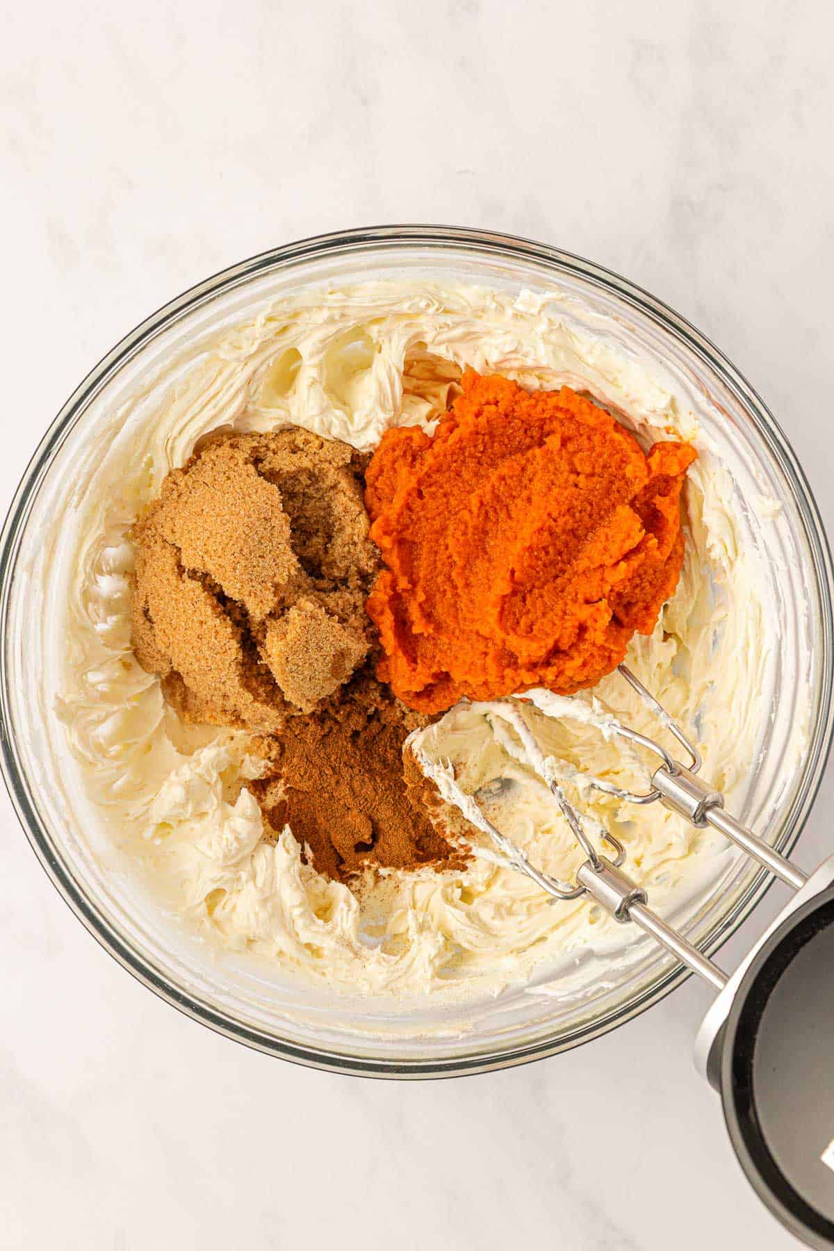 pumpkin cheesecake ingredients in a mixing bowl