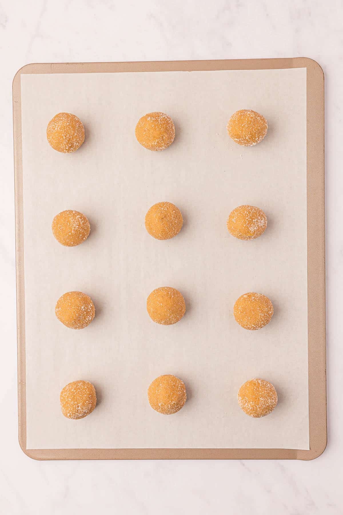 peanut butter dough balls on a baking sheet