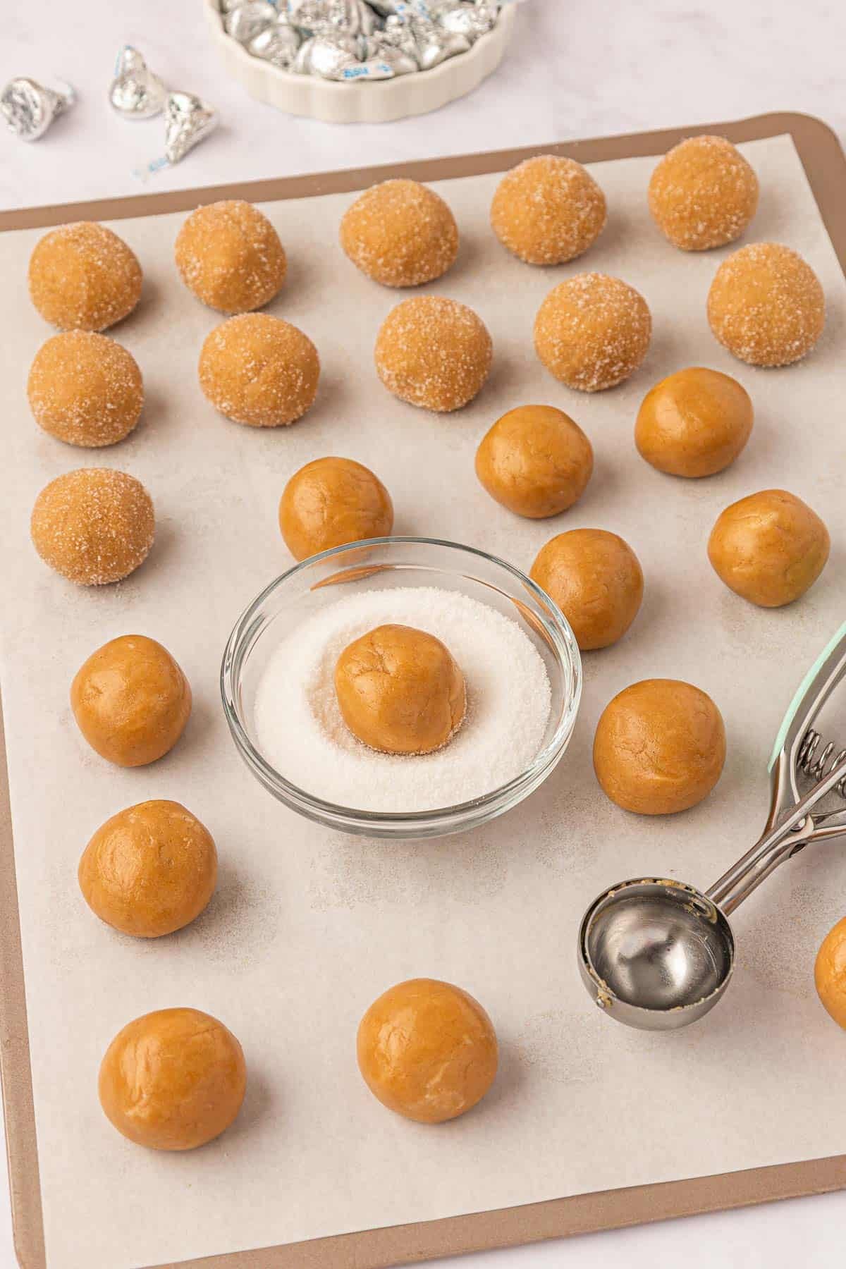 rolling the peanut butter cookie balls in sugar