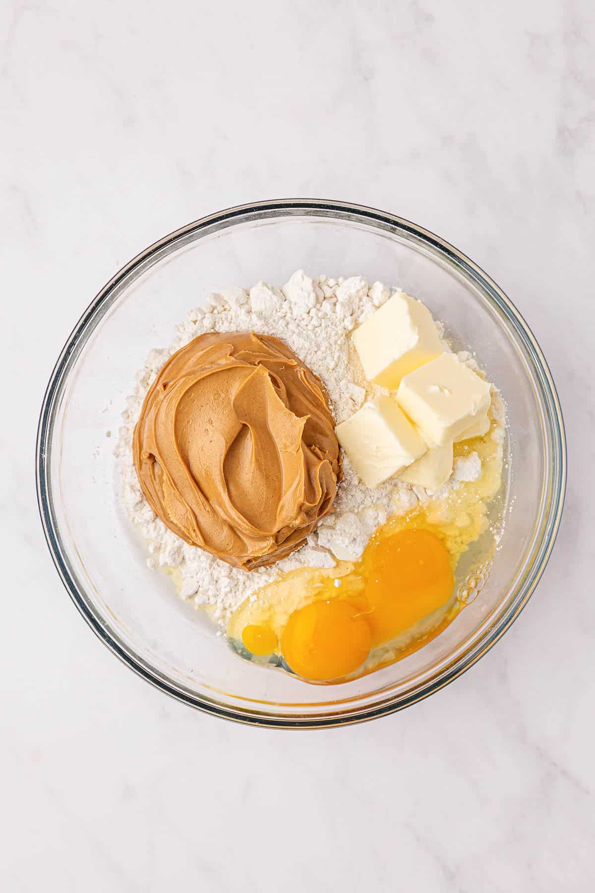 peanut butter, butter, cake mix, and eggs in a mixing bowl